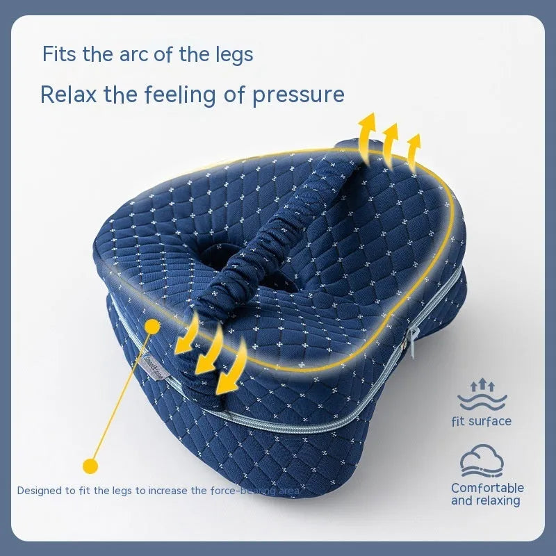 Love heart-shaped dark blue memory foam leg pillow for adults on a bed.