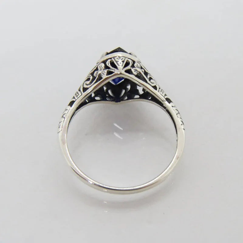Silver women's geometric hollow ring in electroplated alloy on a plain background.