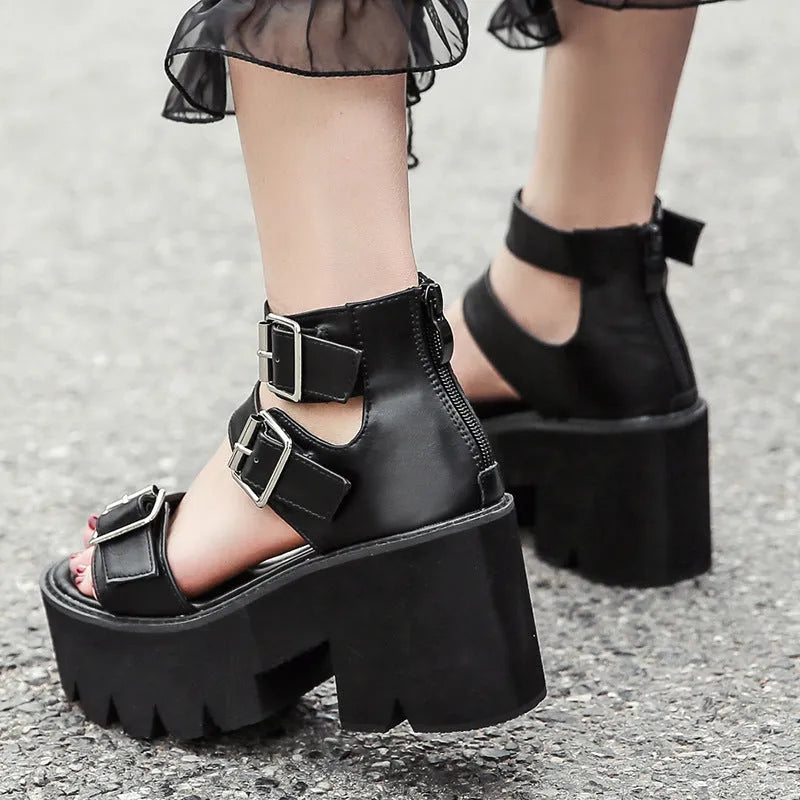 Black women's punk style platform sandals with chunky heel, buckle detail, and back zipper.