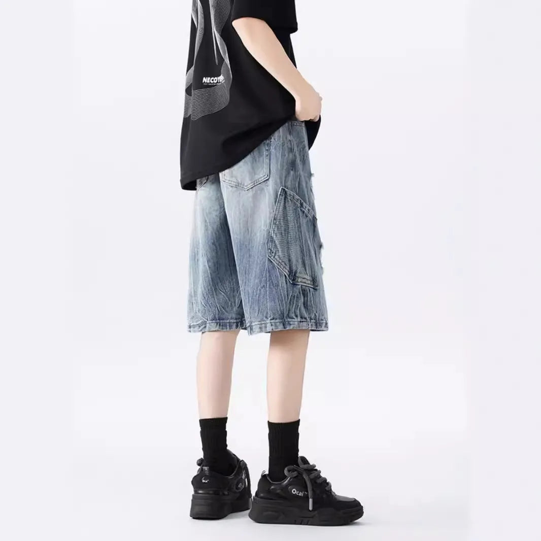 Man wearing black washed ripped denim shorts in a loose, retro style