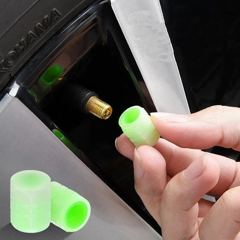Pack of four black rubber car valve caps with luminous glow-in-the-dark tops.