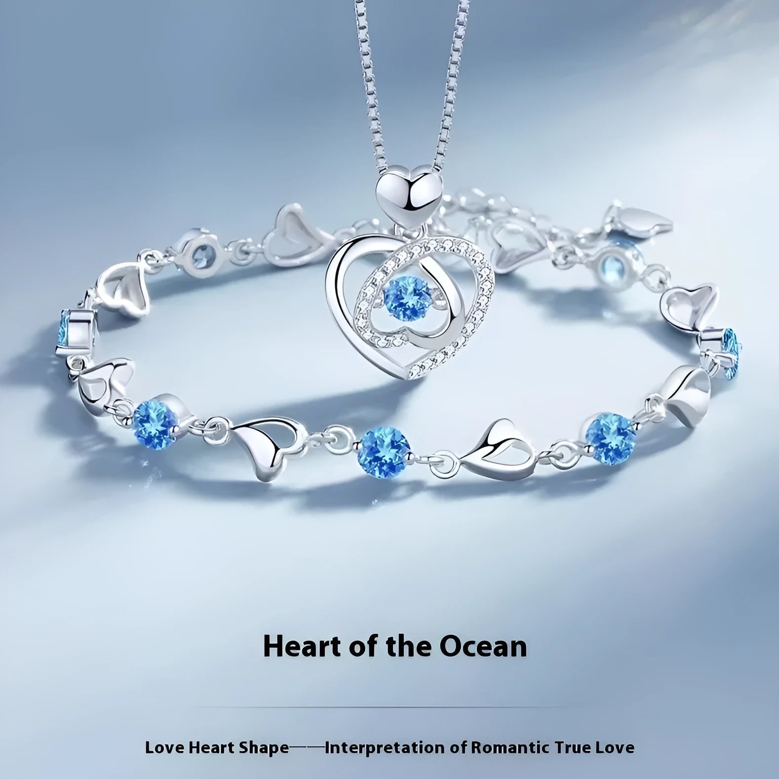 Blue diamond electroplated heart necklace and bracelet set with gem inlay on a geometric pendant.