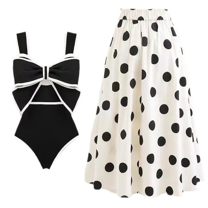 Women's black one-piece swimsuit with white round skirt and bow detail on a mannequin