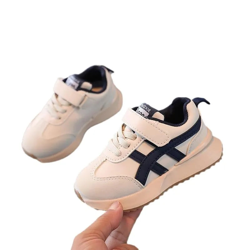 Children's white synthetic leather sneakers with Velcro strap and rubber sole.