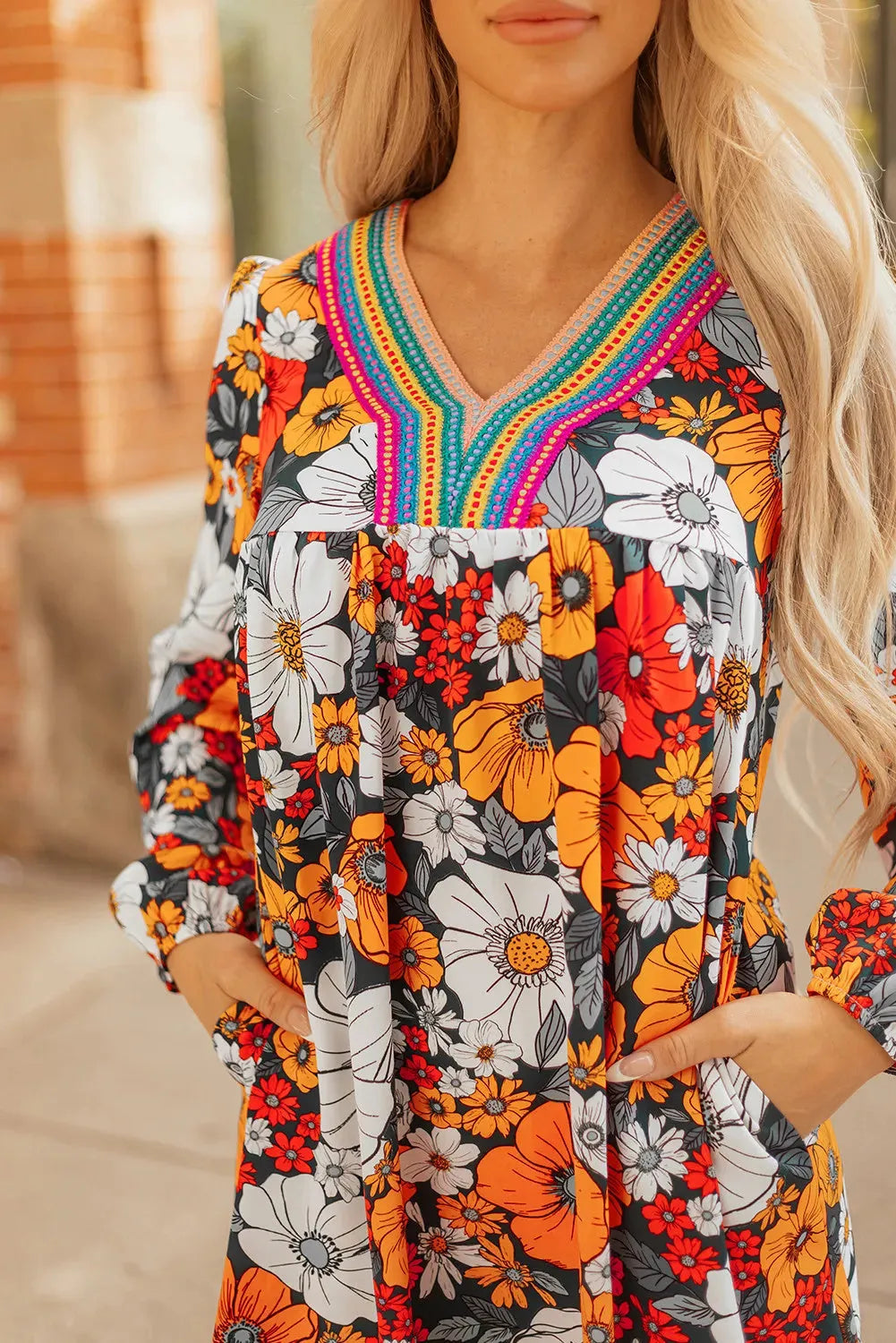 Orange floral print mini dress with lace trim, V-neckline, and long sleeves