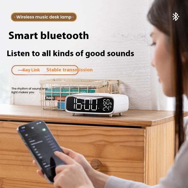 White compact Bluetooth speaker with integrated wireless charging pad and night light on a table
