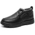 Men's black fleece-lined slip-on winter shoes with a rubber sole on a grey background.