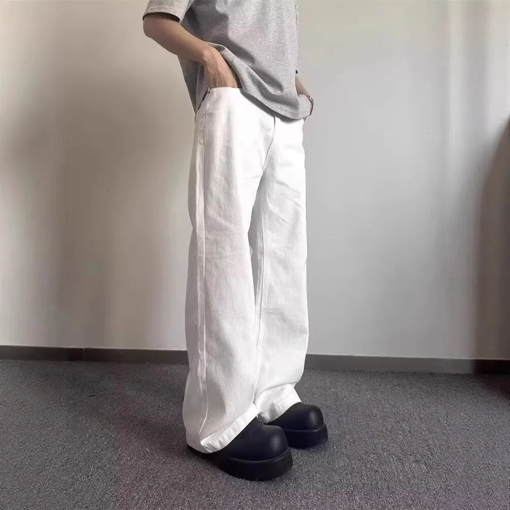Men's white straight-leg denim jeans on a neutral background, showing mid waist and loose fit.