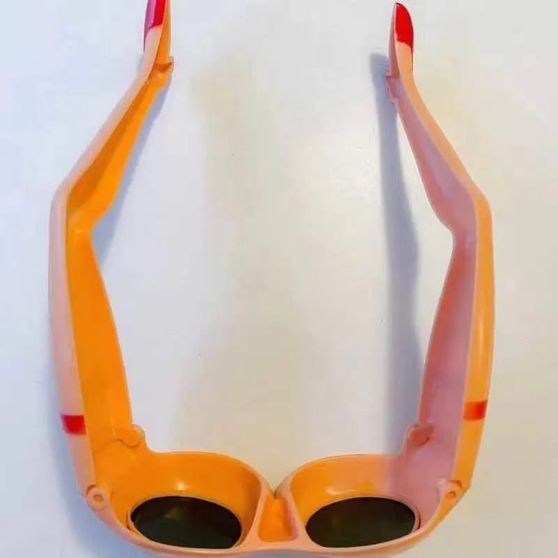 Orange plastic novelty sunglasses with a leg hip frame design on a white background.