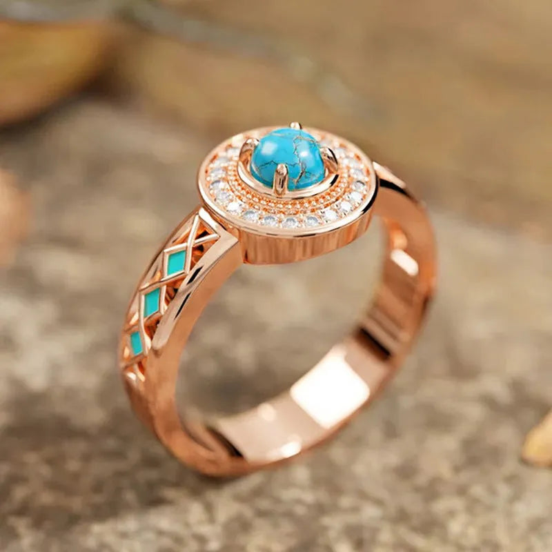 Women's rose gold copper ring with turquoise stone and geometric zircon inlay design.
