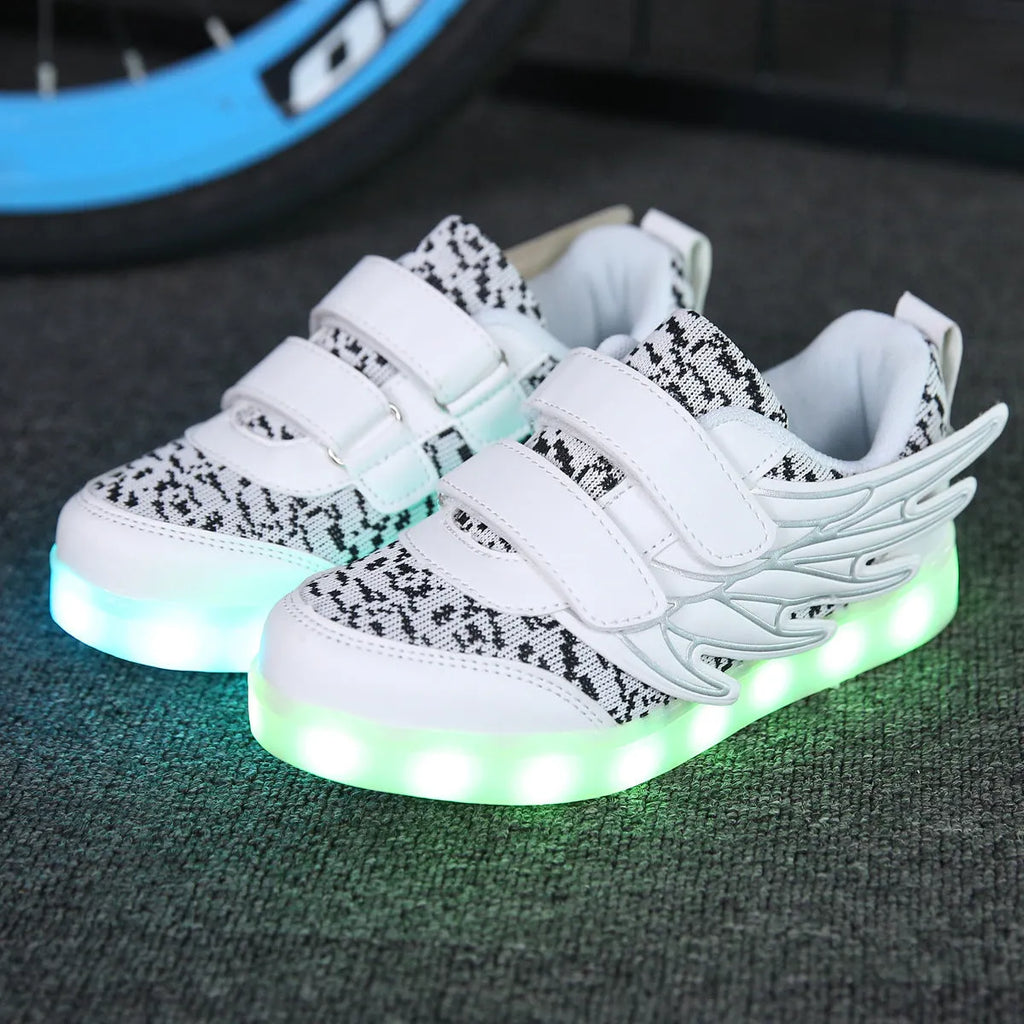 Children's plum red sneakers with colourful LED lights glowing in the soles.