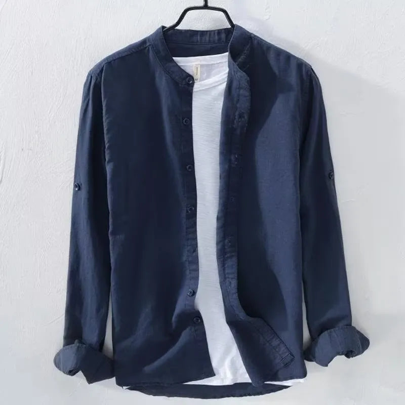Man's loose fitting long sleeve linen shirt in a solid colour on a hanger.