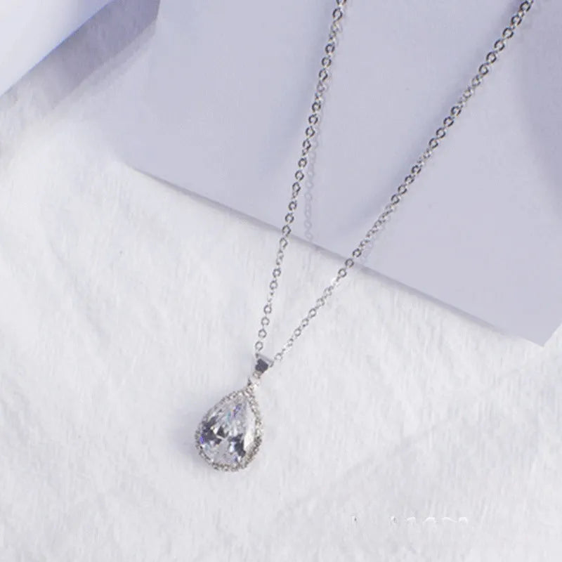 Water drop shaped pendant necklace with geometric design and rhinestone accents in pink colour