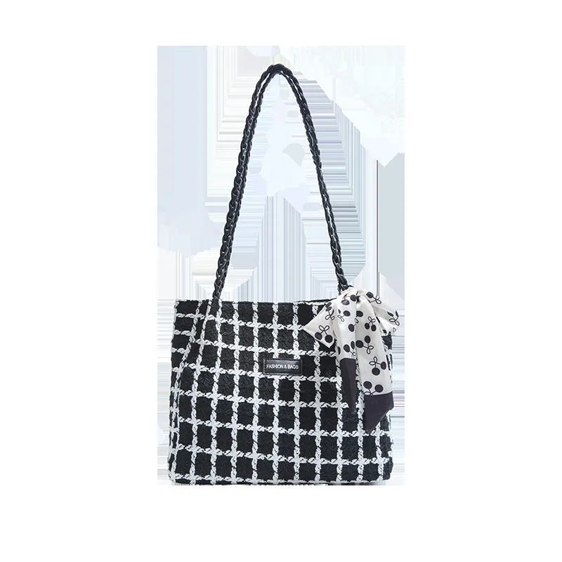 Black woven wool shoulder bag showing horizontal square shape and external pocket.