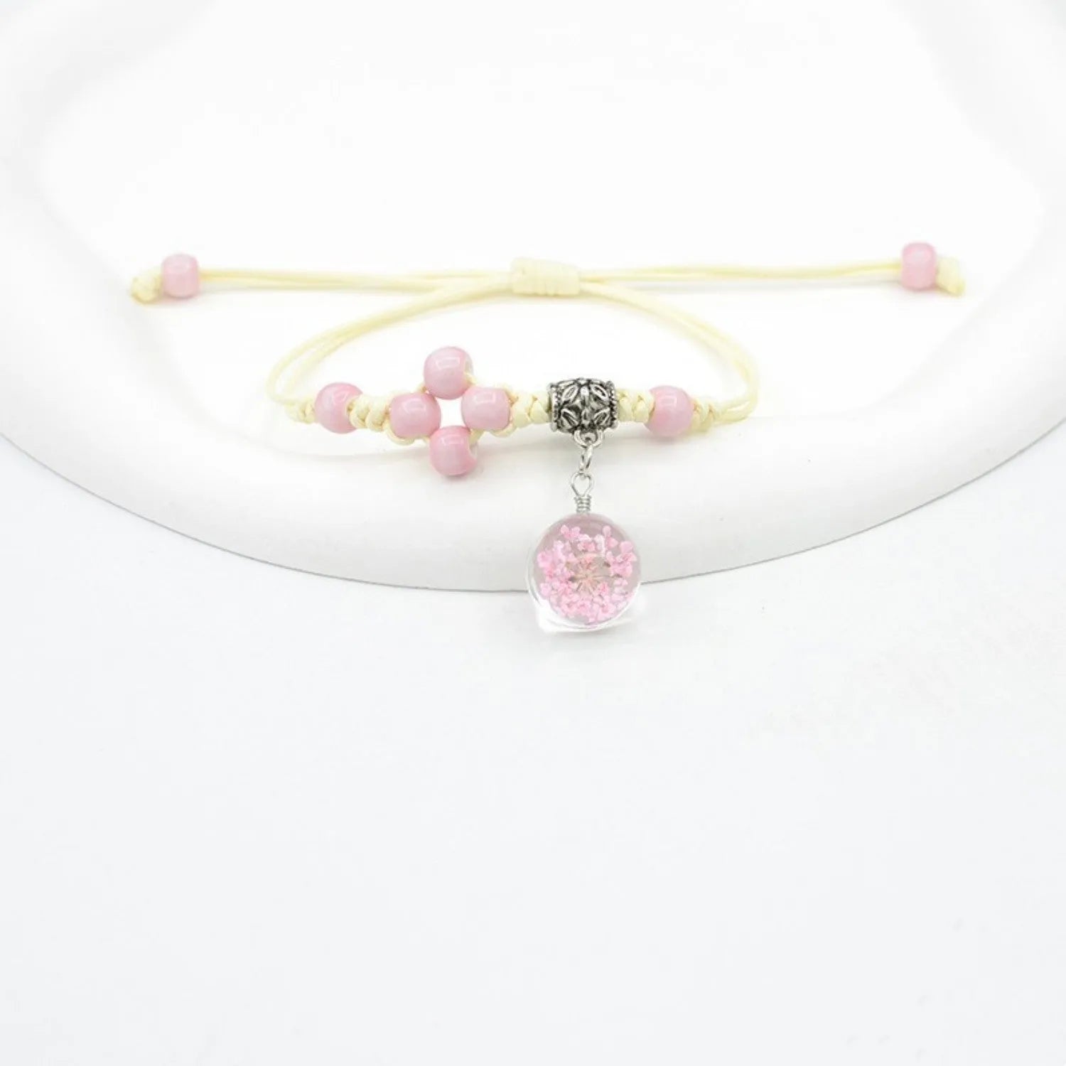 Women's hand-woven glass bracelet with large 1.4cm beads containing dried flowers, shown in blue colour option