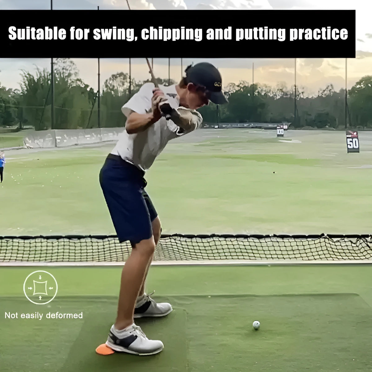 Orange golf training mat with rubber centre disc on practice surface