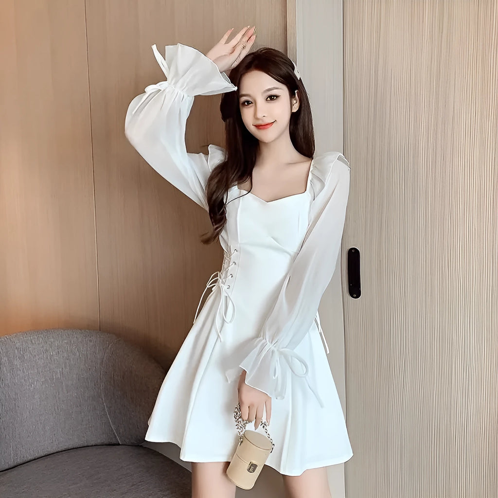 White chiffon patchwork dress on model, showing long sleeves and a long, slim-fitting skirt.