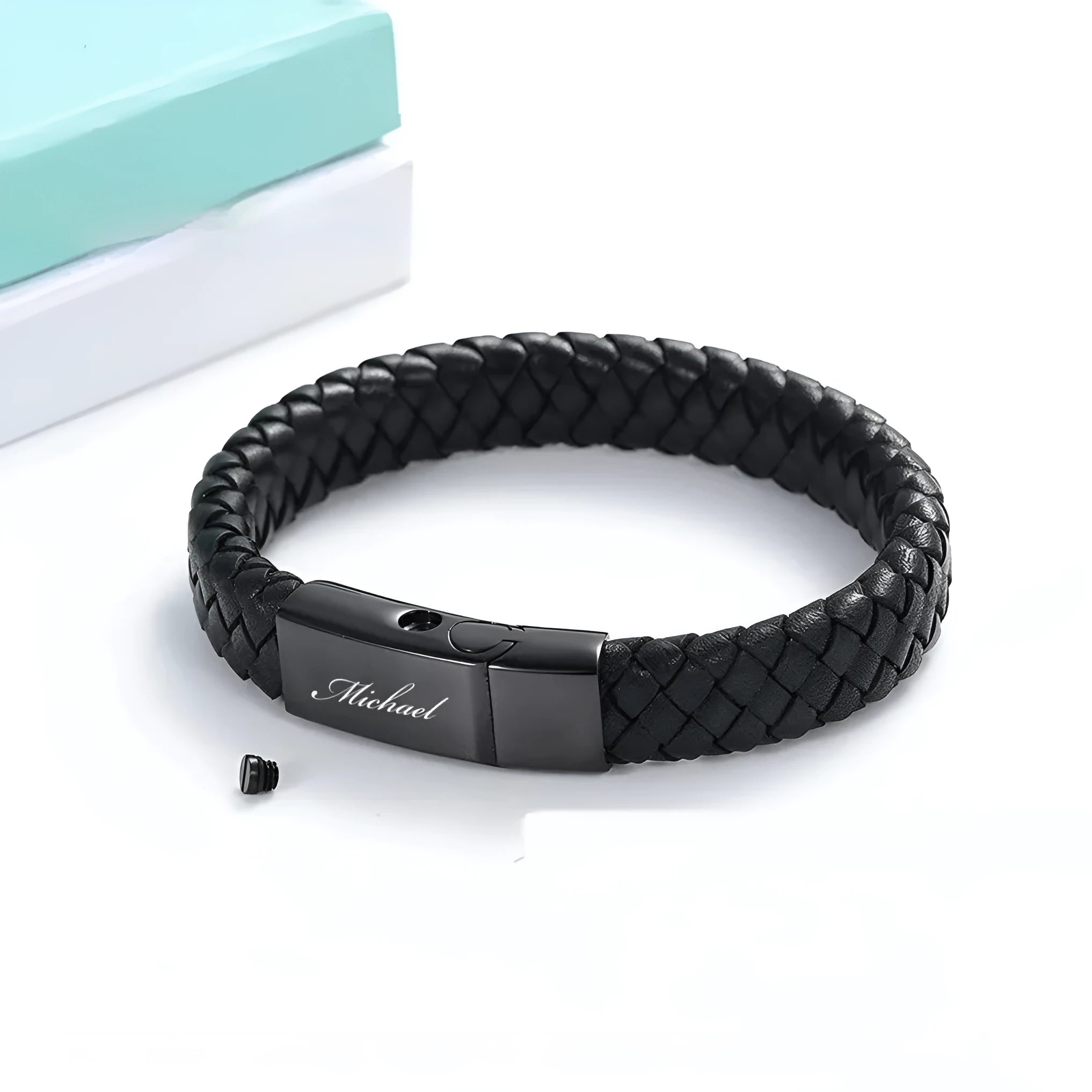 Black leather bracelet with a small stainless steel casket charm, shown in a gift box.