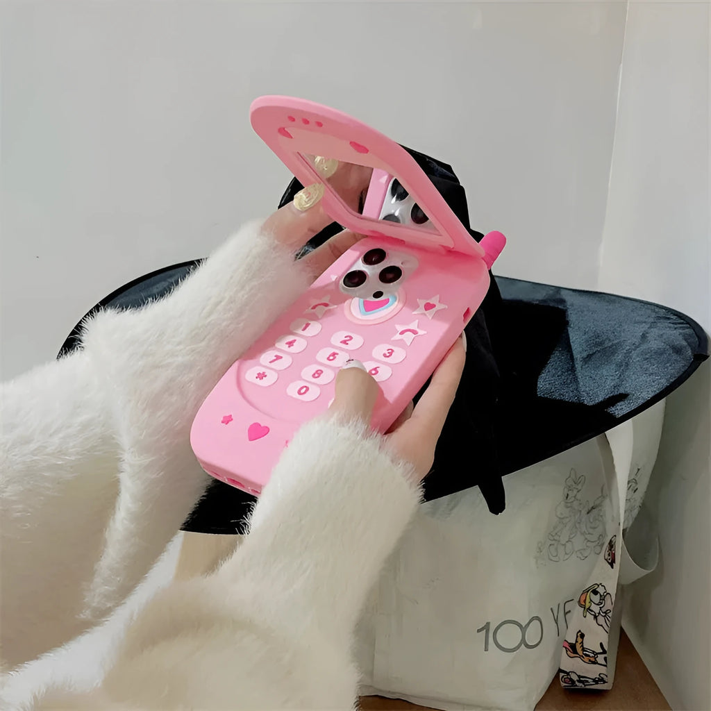 Light pink silicone flip phone case with a built-in mirror, open and showing iPhone model compatibility.