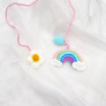 Handmade crocheted avocado with rainbow flower car pendant in wool yarn.