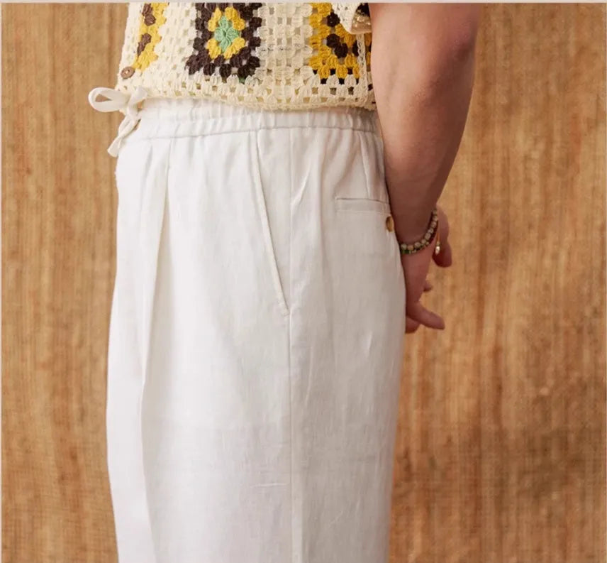 Linen straight-leg trousers in greige with an elasticated high waistband on a neutral background.