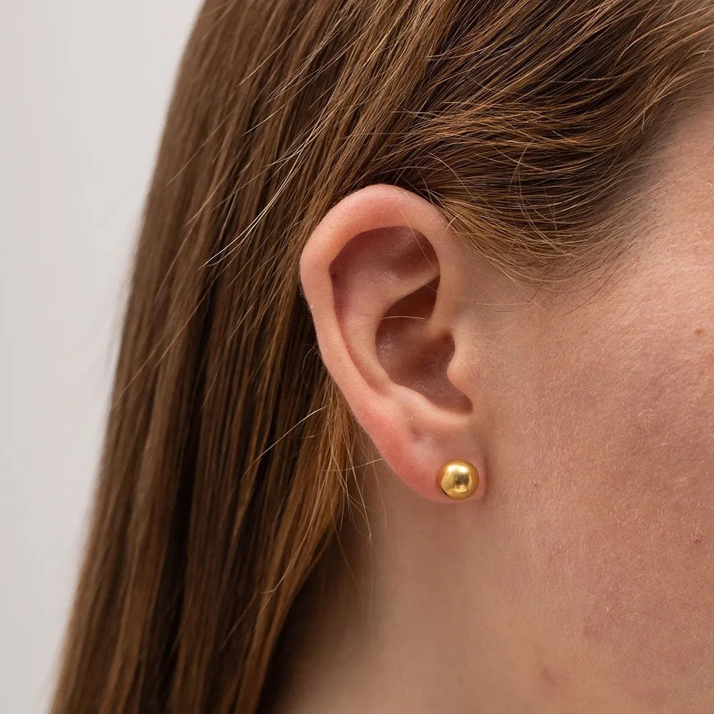 Stainless steel 18K gold ball stud earrings in round geometric design on simple stud posts.