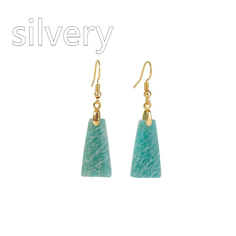 A pair of trapezoid-shaped earrings with a rough green amazonite stone set in a geometric gold or silver metal frame.