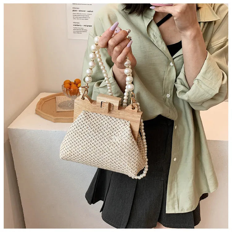 Women's straw shoulder bag with pearl chain detail and multiple zipper compartments in neutral colour