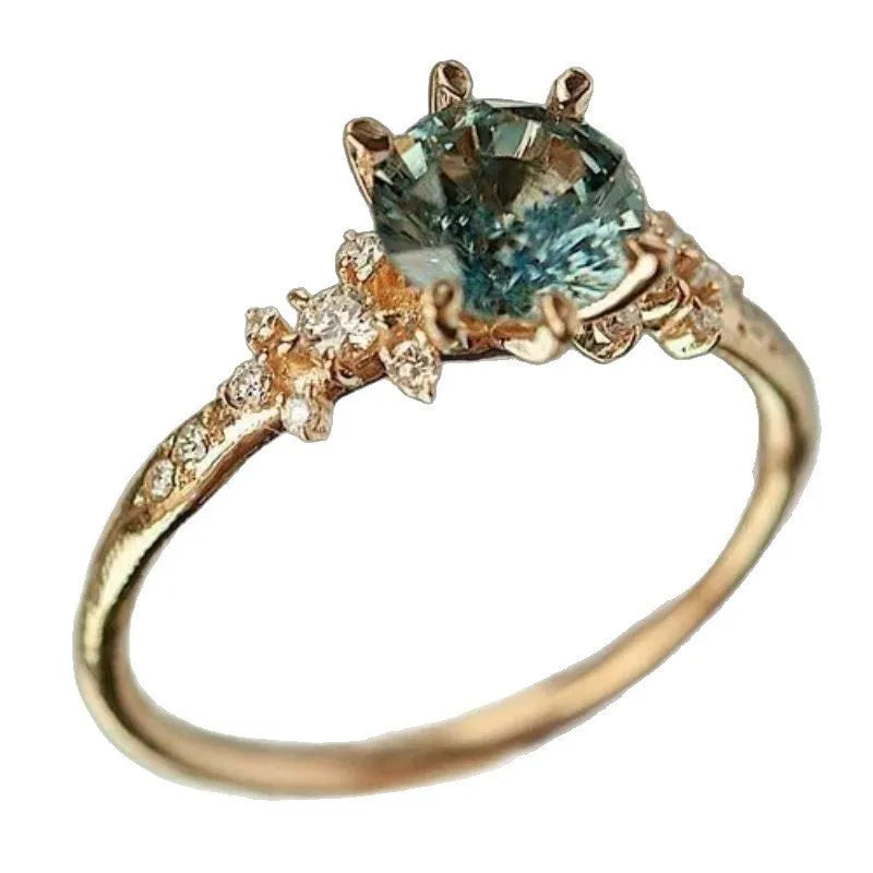 Gold plated geometric ring with claw setting holding inlaid zircon stones, shown in size options 6 to 10.