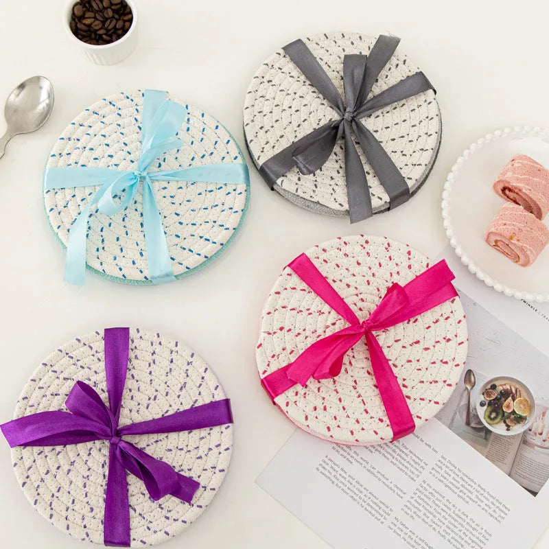 Set of three round cotton cord coasters in blue colour, 18cm diameter, on a table.
