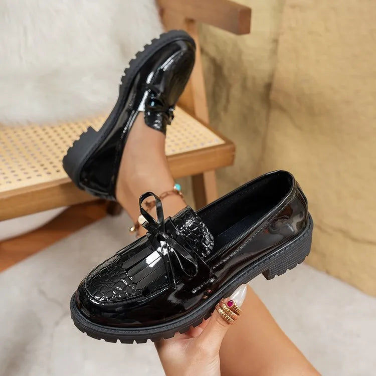 Women's black loafers with a decorative bow on the toe, made from synthetic PU material.