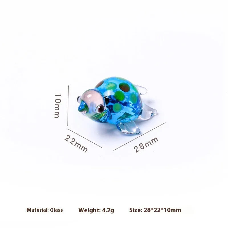 Glass geometric turtle ornament in blue head with blue shell colour variation on wooden desktop