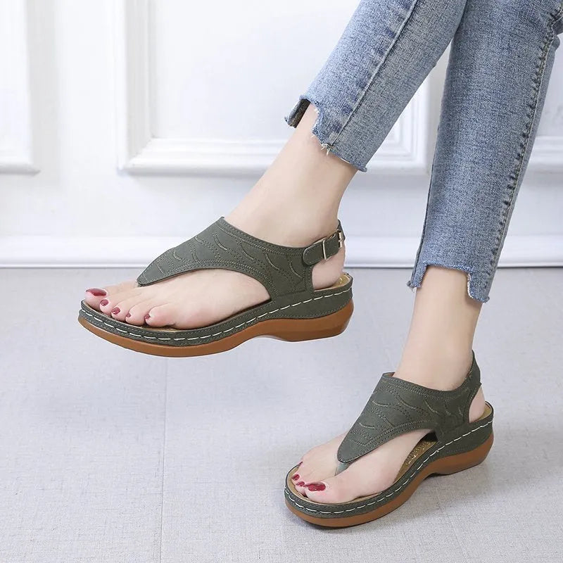Women's black wedge heel sandals with an adjustable back strap buckle on a white background.