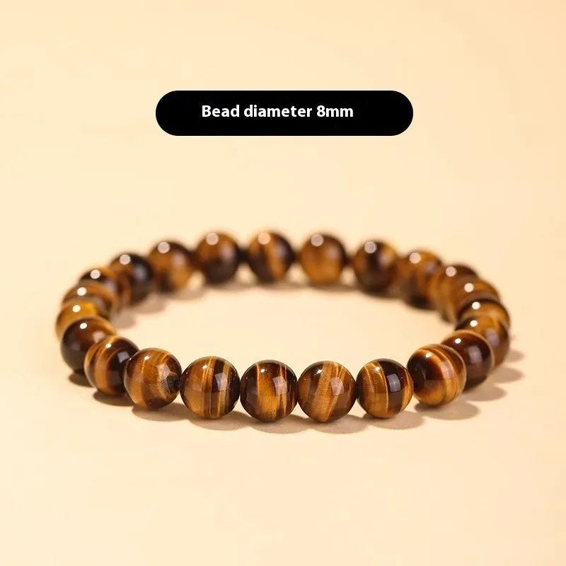 Tigereye stone bead bracelet with a single central Dzi bead featuring a circle design.