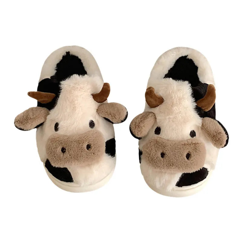 White cartoon cow plush slippers for women with a non-slip textured sole.