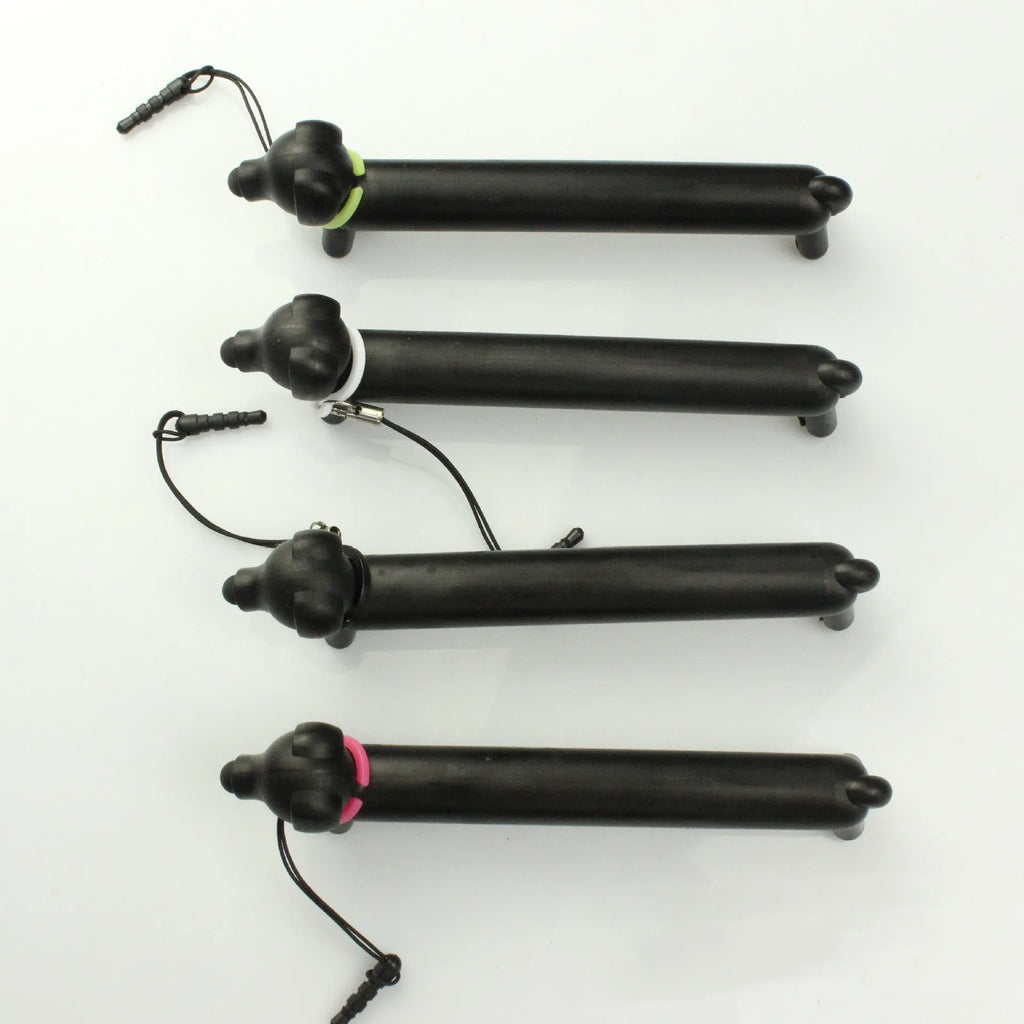 Black dog-shaped touch screen stylus pen shown next to a mobile phone on a desk.