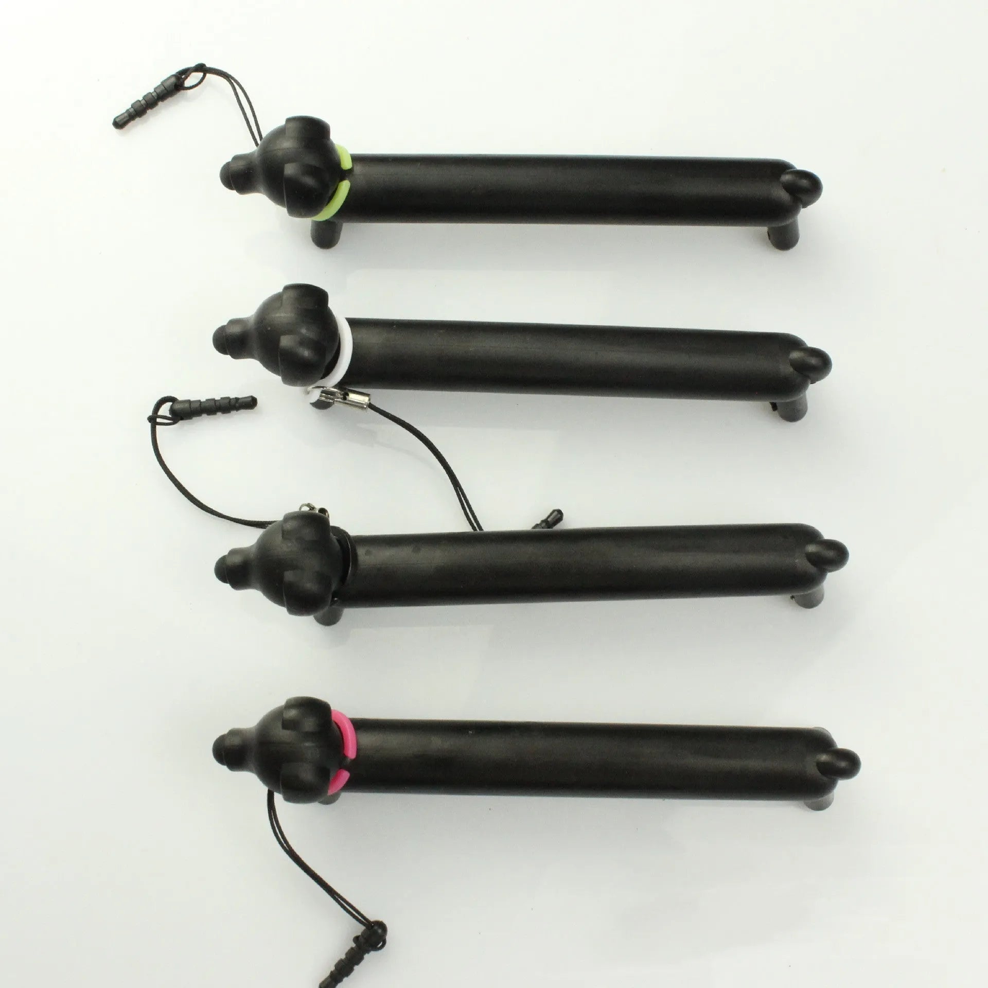 Black dog-shaped touch screen stylus pen shown next to a mobile phone on a desk.