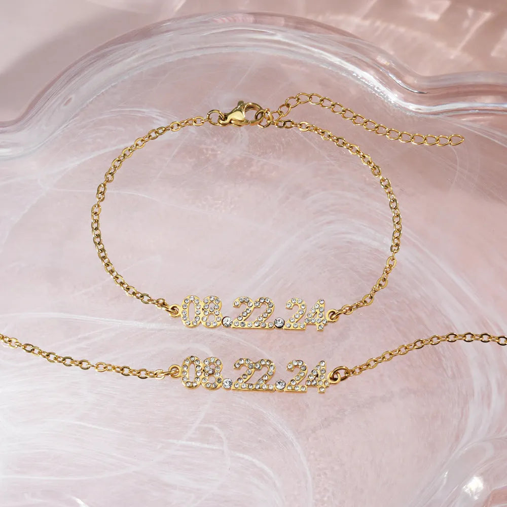 Stainless steel digital bracelet or necklace with diamond-set bezel showing time display, in gold, rose gold, or steel finish.